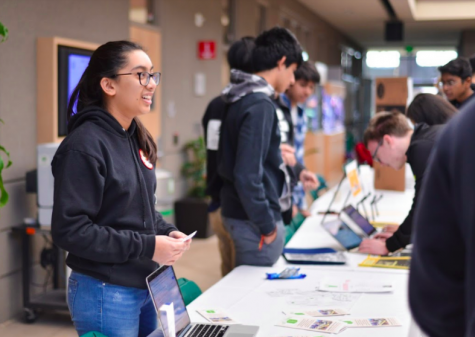 Maya Shukla (11) presents her service opportunity to students walking by. The fair took place after advisory today.
