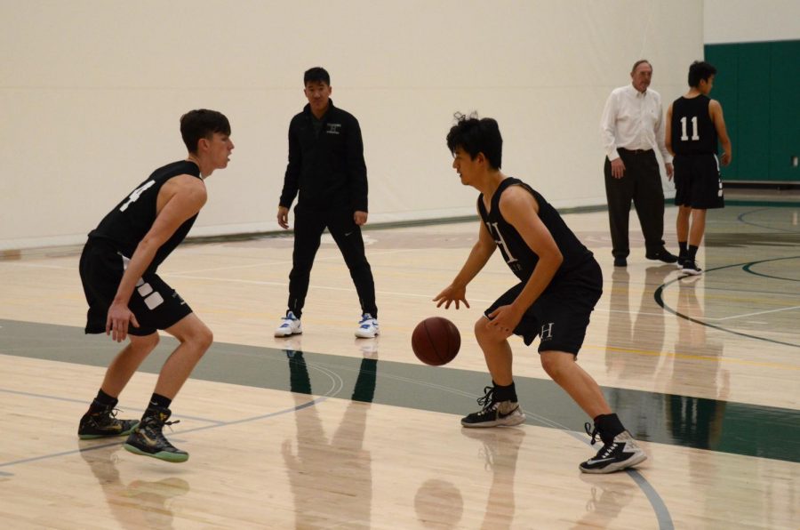  Richard Wang (12) tries to dribble past Jack Connors (11) in a  one-on-one drill during basketball practice. This year, the team is headed by captains Gene Wang (12) and Jack. 