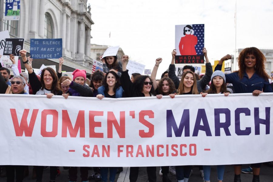 The Womens March banner follows closely behind the indigenous rights activists during the march down Market Street to the Embarcadero in San Francisco.