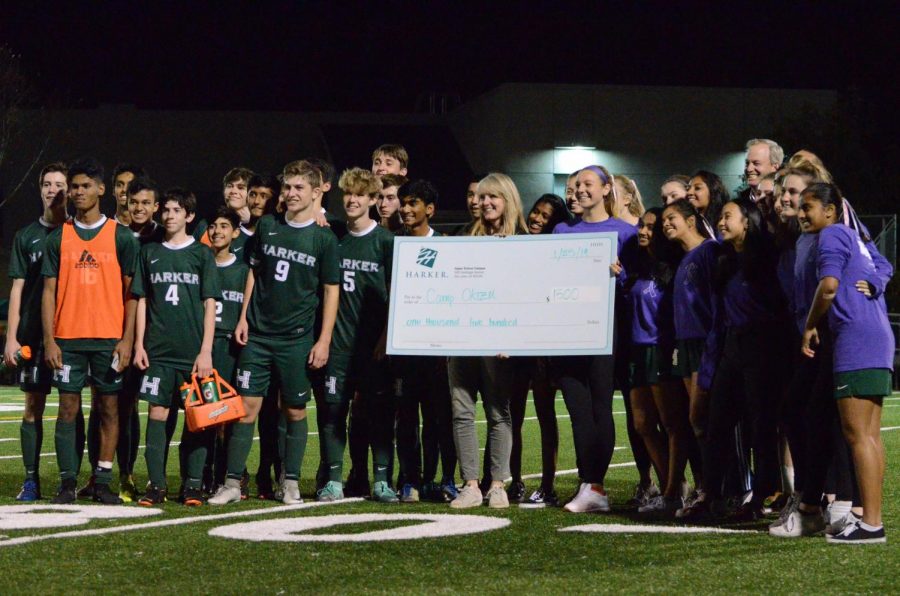 The soccer teams pose with a representative from Camp Okizu during halftime of the varsity boys game. The teams collectively announced the $1,500 they'd raised in total, and thanked everyone for coming out to show their support. 
