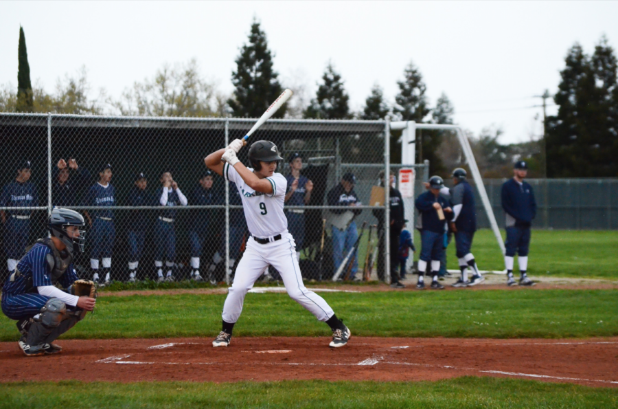 Trevor Thompson (12) steps up to bat, preparing for the pitch to be thrown. Despite their Friday game being cancelled, the Eagles still played well during the match, with strategic hits from freshman Bobby Wang and senior Zachary Hoffman and a dive for home base by junior Max Lee.
