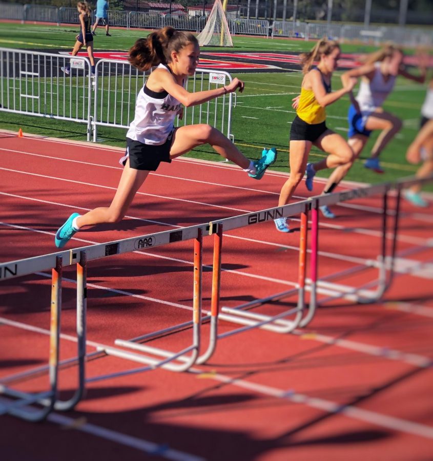 Natasha Matta (9) leaps over a hurdle during the varsity 100 meter hurdles during final WBAL competition on Friday, May 4. Natasha placed third in the final 100m hurdles event.