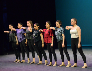 Members of both JV and Varsity dance stand in a line and execute a move from Olivia Esparzas (12) senior showcase dance.