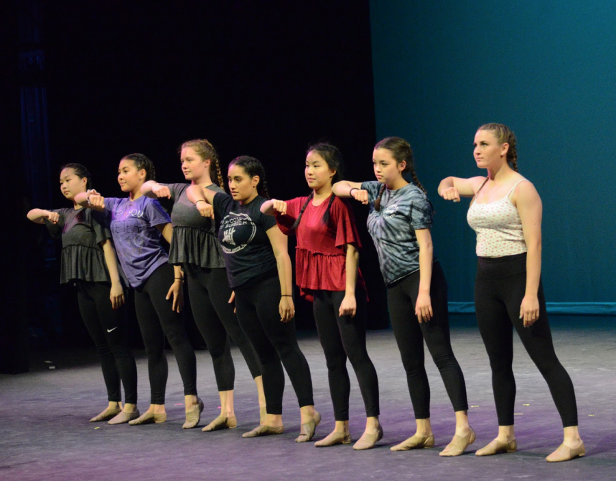 Members of both JV and Varsity dance stand in a line and execute a move from Olivia Esparza's (12) senior showcase dance.