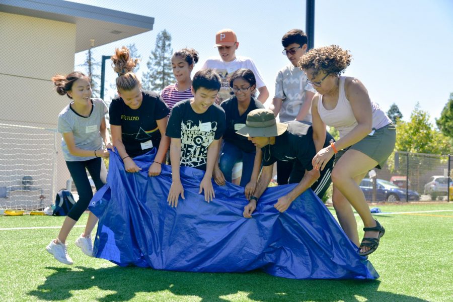 A freshman advisory tries to make its way across Davis Field while jumping with a tarp. Freshman field day encourages teamwork and friendship.