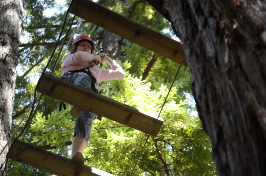 Angelina Yuzifovich (10) walks on a ladder connecting two trees.