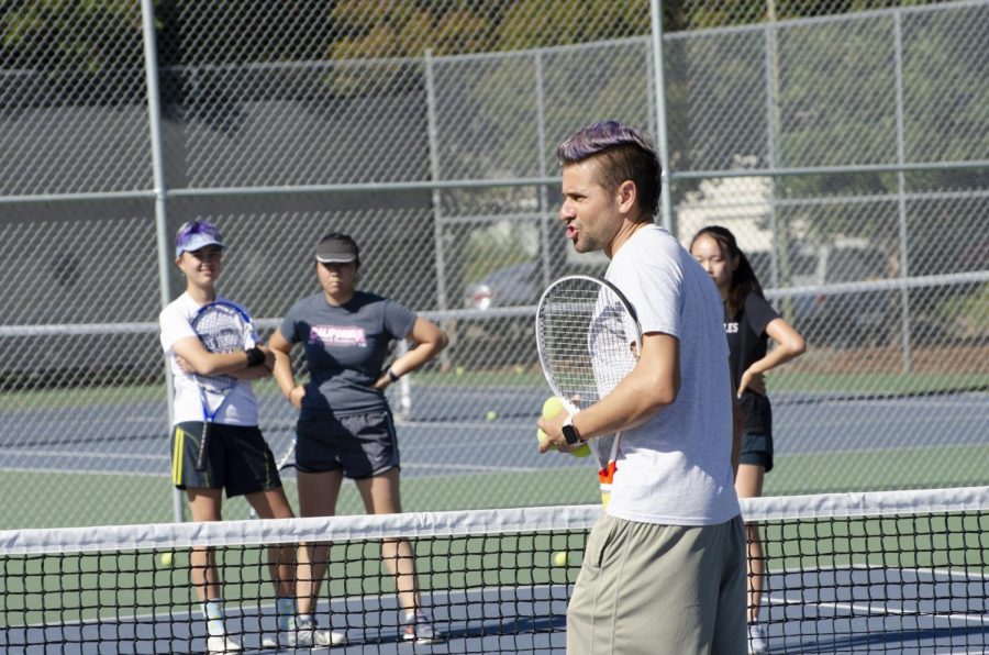 Assistant coach John Paul Fruttero talks to the girls tennis team, going over a specific drill. “It’s a lot of work, because we have practice every day for two hours,” freshman Alissa Huda said of tennis practices. “But [there’s] been a lot of team bonding, and [we have become] a lot closer.” 