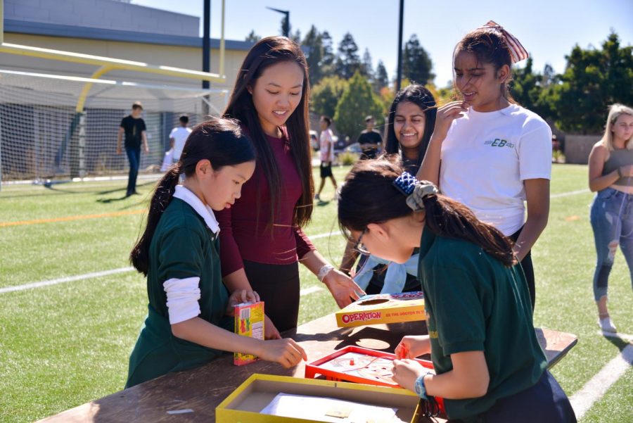 Katelyn Vo (12) plays the board game Operation with two lower school students after lunch yesterday. Seniors were given the chance to bond more with their buddies, kicking off their final year before college.