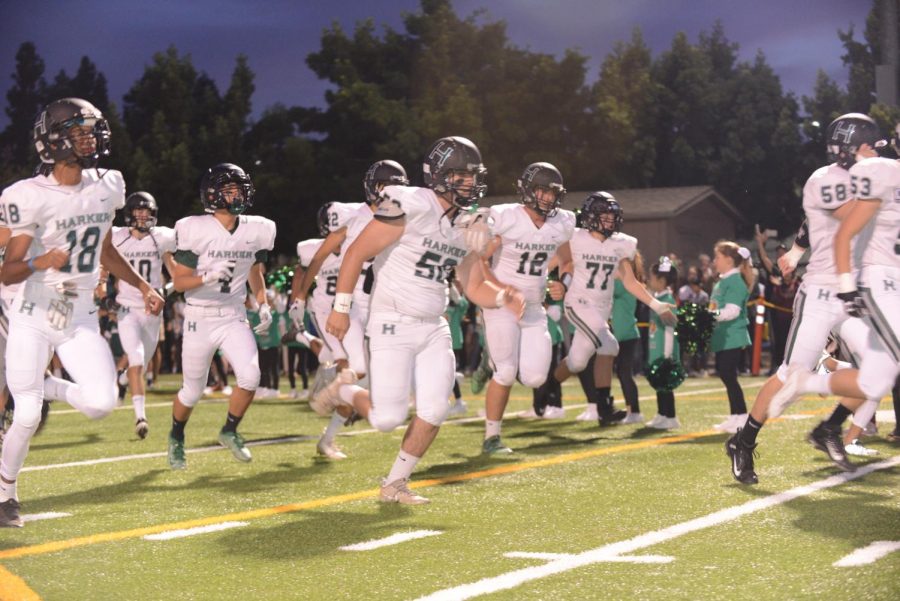 The Eagles football team runs onto the field. 