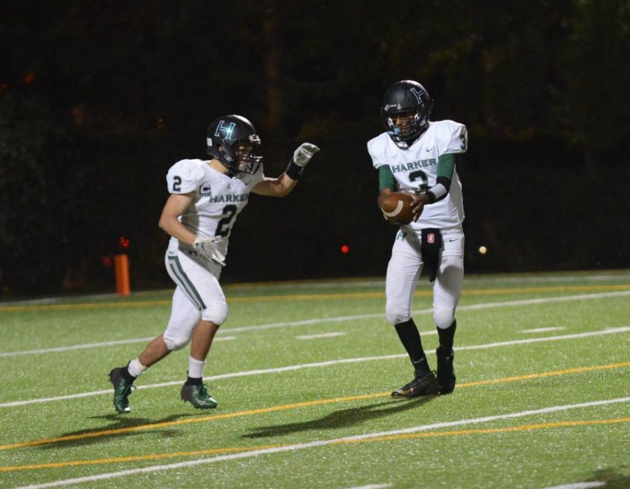 Vijay Vyas (11) hands off to running back Devin Keller (12).