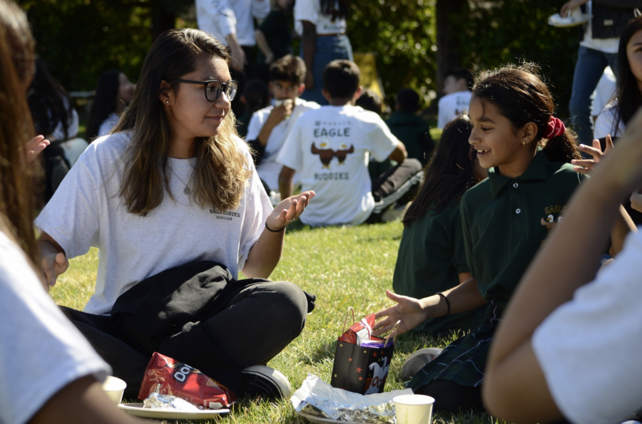 Maddie Hansen (10) converses with her Eagle Buddy over a lunch of burgers and chips on the Bucknall field. The class of 2022 traveled to the Bucknall campus to meet their Eagle Buddies for the first time yesterday.
