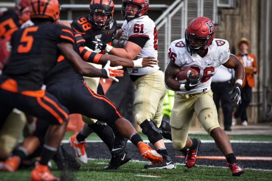 Harvard running back DeMarkes Stradford makes a move before carrying the ball past blockers on the line of scrimmage.