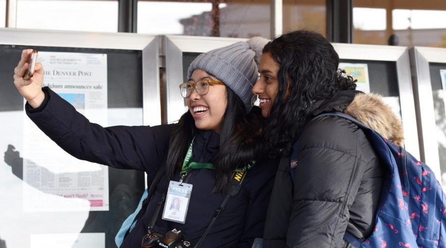 Winged Post Editor-in-Chief Gloria Zhang (12)  and Aquila Managing Editor Varsha Rammohan (11) take a  selfie in front of a display of newspapers on Nov. 20 outside of the Newseum. The Newseum, the only national museum dedicated solely to journalism, will be shut down as of Dec. 31, 2019.
