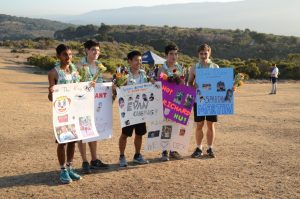 Seniors Nikhil Sharma, Grant Miner, Evan Cheng, Richard Hu and Martin Bourdev pose with their posters and candy-filled garlands. This meet was their final cross country meet of high school. 