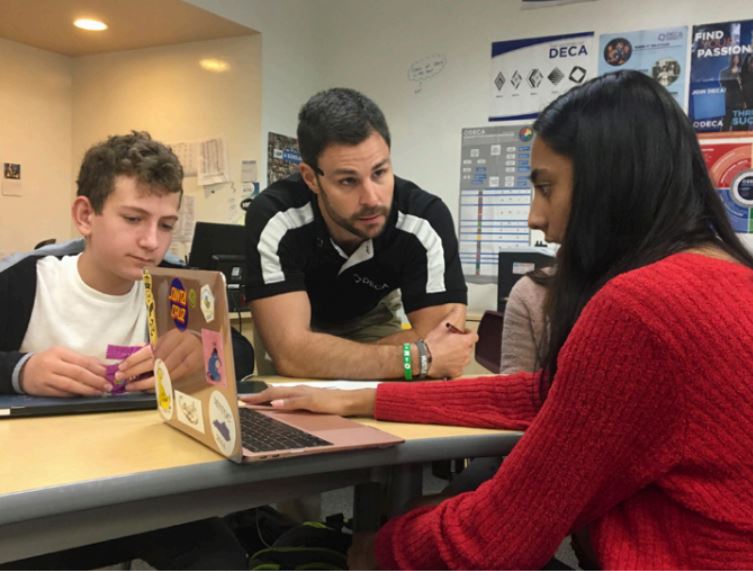 Business and Entrepreneurship teacher Juston Glass assists two freshmen in his class. The fall DECA conference presents an opportunity for freshmen to compete through roleplay interviews and practice for the upcoming SVCDC conference in January.
