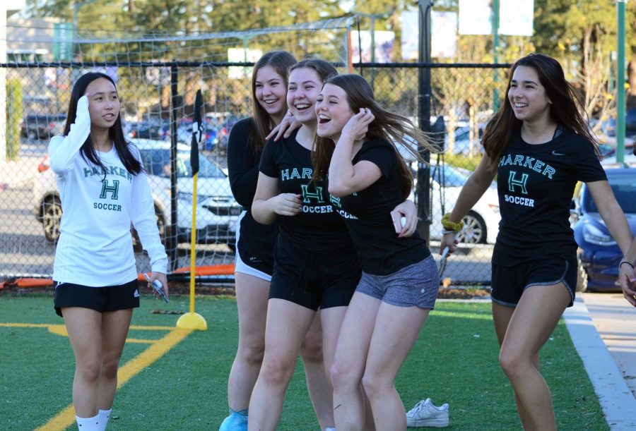 Members of the girls soccer team cheer on the boys during their comeback win last Wednesday against Sacred Heart. “It’s my second time watching. The first time I had a lot of fun, and it was a really close game too. We [have] a good group of guys and it's fun to support the kids who are in my math class and see them work hard on the field.” said Arjun Virmani (11).