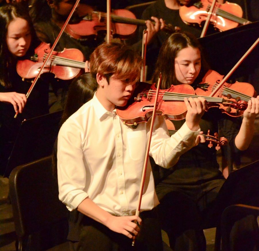 Senior violin soloist Hanoom Lee leads the orchestra in Pablo de Sarasates “Zigeunerweisen during the annual winter concert last Friday. The upper school orchestra was joined by the upper school jazz and lab bands, with all three groups performing pieces from their repertoires.