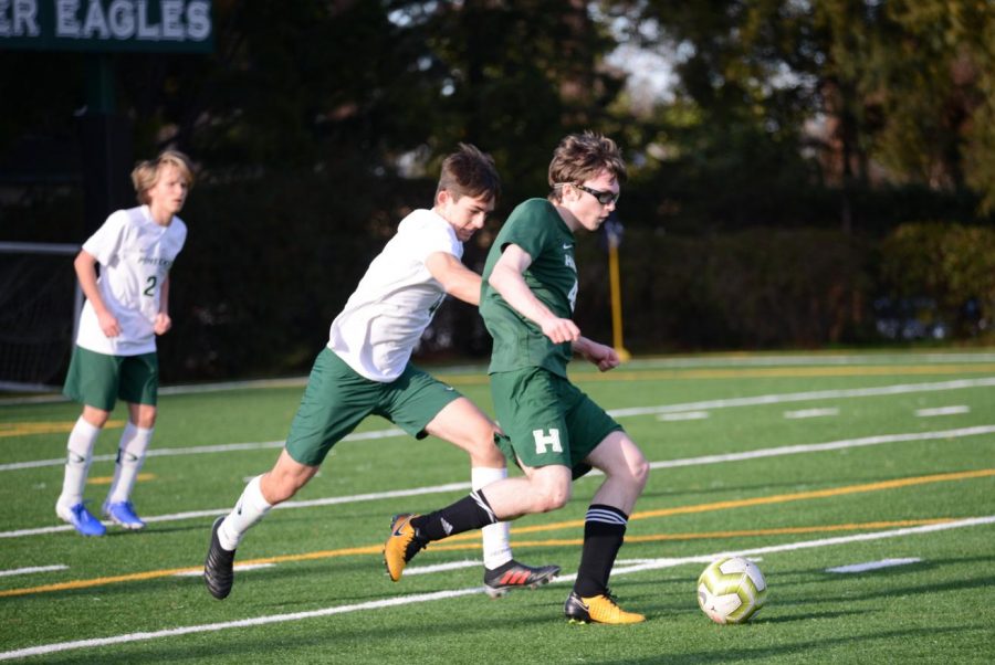 JV player Anton Novikov (11) fights to possess the ball from a Pinewood player during the annual Kicks Against Cancer event.
