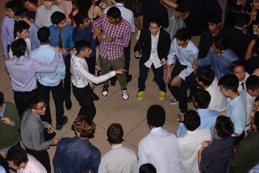 Anish Kilaru (11) points at someone in front of him, as a group of students dance in a circle during the Winter Ball.