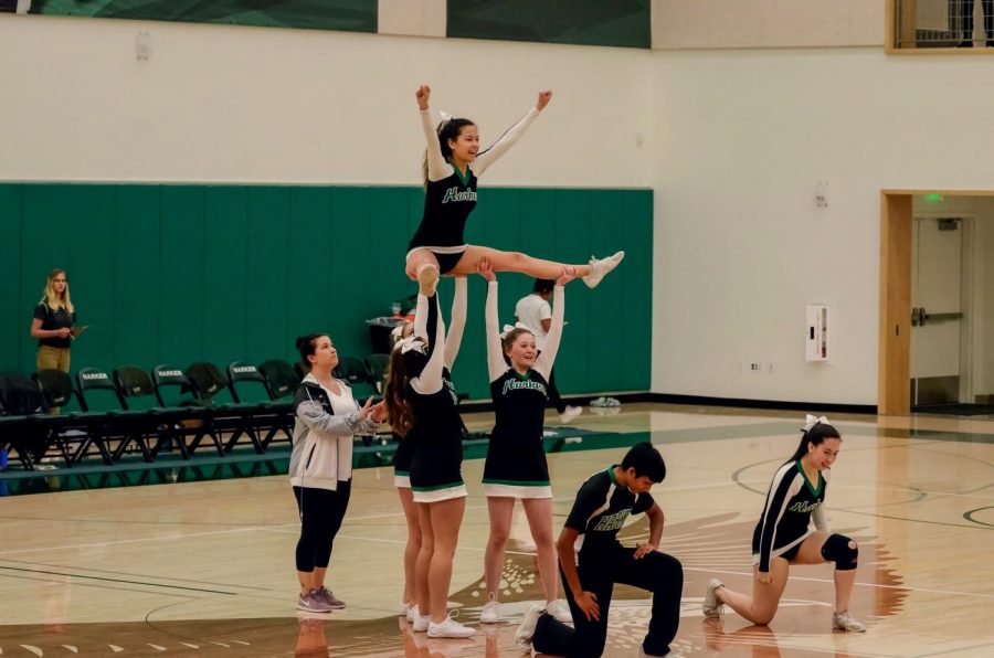 Members of the varsity cheer squad perform during halftime of the varsity boys basketball game last Thursday. “It was a little rough, we definitely could have played better,” Emma Crook (10), a member of varsity cheer, said.
