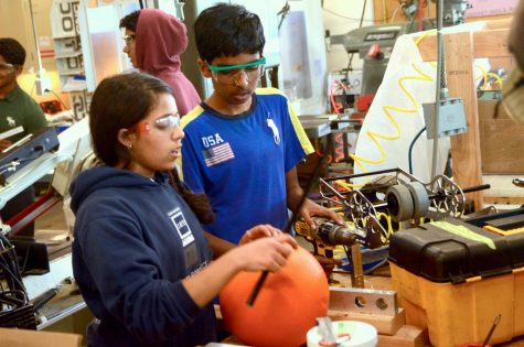 Aditi Vinod (11) shows Rohan Rashingkar (10) how to design a robot piece.