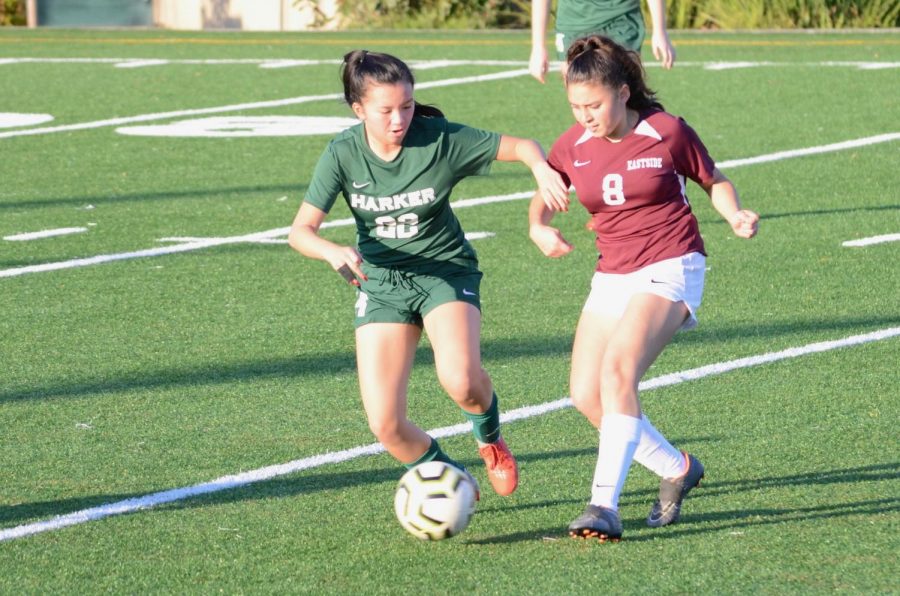 Aria Wong (11), co-captain of the varsity girls soccer team, holds her arm out in front of an Eastside player, attempting to block her from stealing the ball. The Eagles defeated Eastside 8-0 last Tuesday after an impressive game, their first league match of the season.