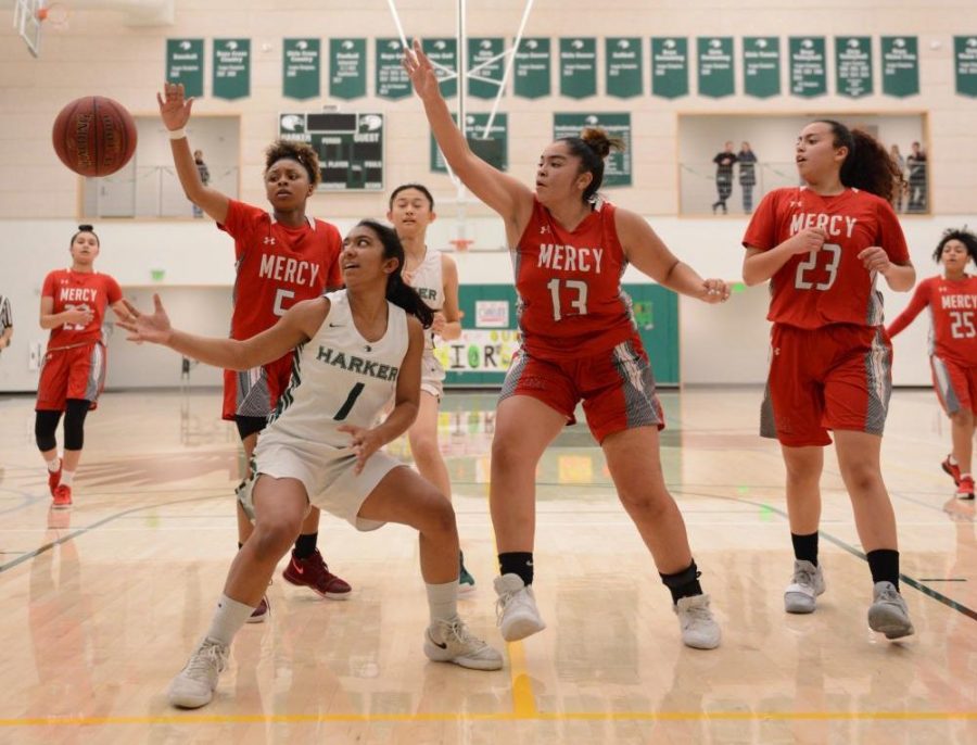 Co-captain Maria Vazhaeparambil (11), surrounded by three Mercy defenders, reaches for a loose ball during the first quarter of the Eagles matchup last Friday. The girls started off evenly, tied 27-27 heading into the locker room at halftime.  