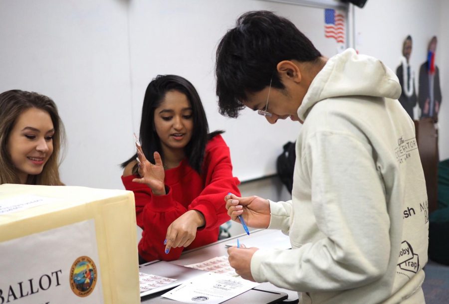 AP Government student Riva Saksena helps Shray Alag (11) turn in his ballot during fifth period on Monday. Students were able to cast their ballot for presidential candidates from all parties as well as vote on California’s Proposition 13, which regulates funding for education.