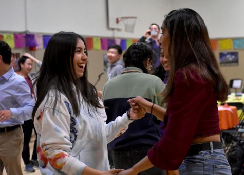 Nerine Uyanik (12) and Simren Gupta (12) dance together during the salsa competition of La Noche Cultural. The salsa competition took place at the end of the night, after  the dinner and student performances.