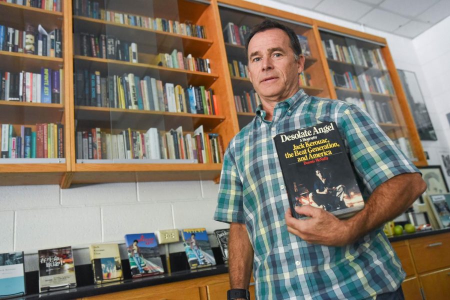 Upper school English teacher Charles Shuttleworth poses with Desolate Angel, a biography of Jack Kerouac. Shuttleworth, who was chosen as the annual Moses Greeley Parker lecturer, presented his research on American novelist Kerouac in a virtual lecture titled “Kerouac: The Buddhist Years.”

