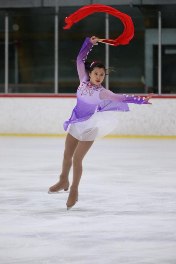 Alice Feng (11) performs her skate routine with a flowing red fan as a prop. Her bejeweled dress recalls elements of Chinese culture, an inspiration to the routine.