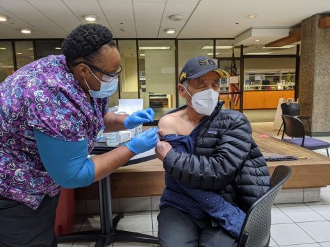 A nurse administers a dose of the Moderna vaccine to Cigeng Zhu, grandfather of Sabrina Zhu (10), at the Santa Clara Valley Medical Center. Those in high-risk groups, including healthcare workers, essential works, and the elderly, are given first priority.
