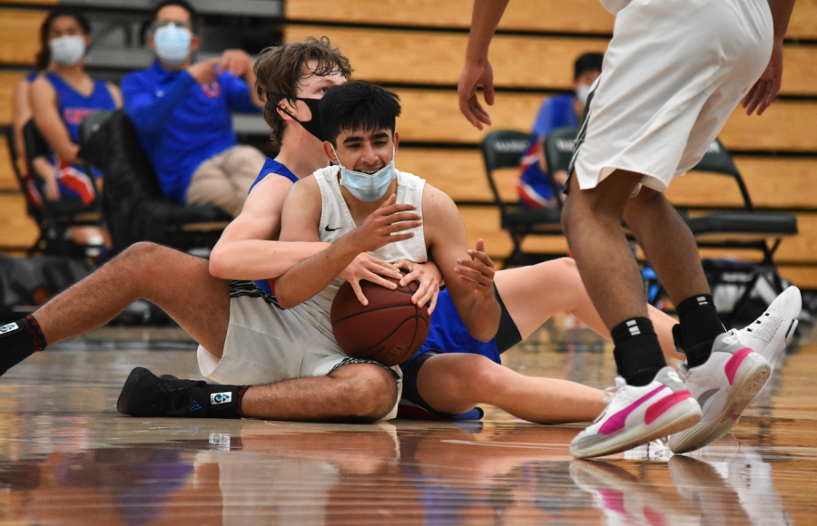 Arjun Virmani (12) fights with a defender for the basketball in the team’s match 50-44 victory against Crystal Springs on April 21. The team’s next match is against Sacred Heart at home at 6 p.m. on Wednesday.