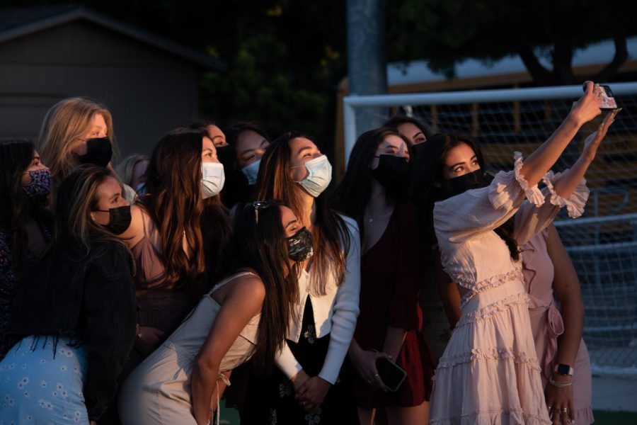 Farah Hosseini (12) holds up her phone to take a selfie with friends at Baccalaureate on May 21. The ceremony lasted from 8 to 9 p.m. and was followed by the Lifer Event. 