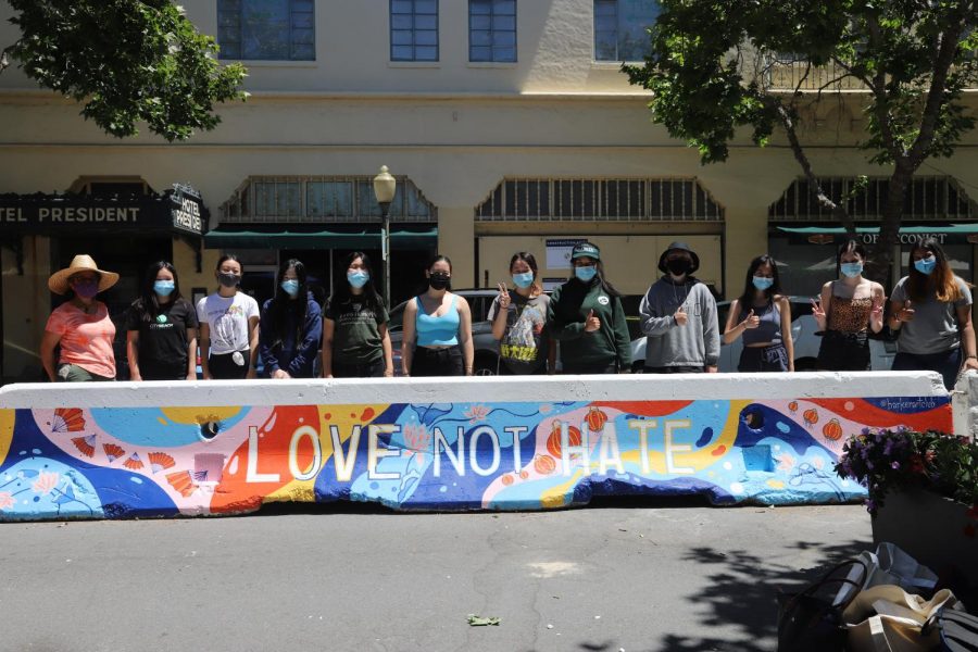 Art Club members stand behind their work after the completion of the Love Not Hate mural in Downtown Palo Alto on June 12. Club members painted the mural in support of the Stop AAPI movement and to show solidarity with the AAPI community.