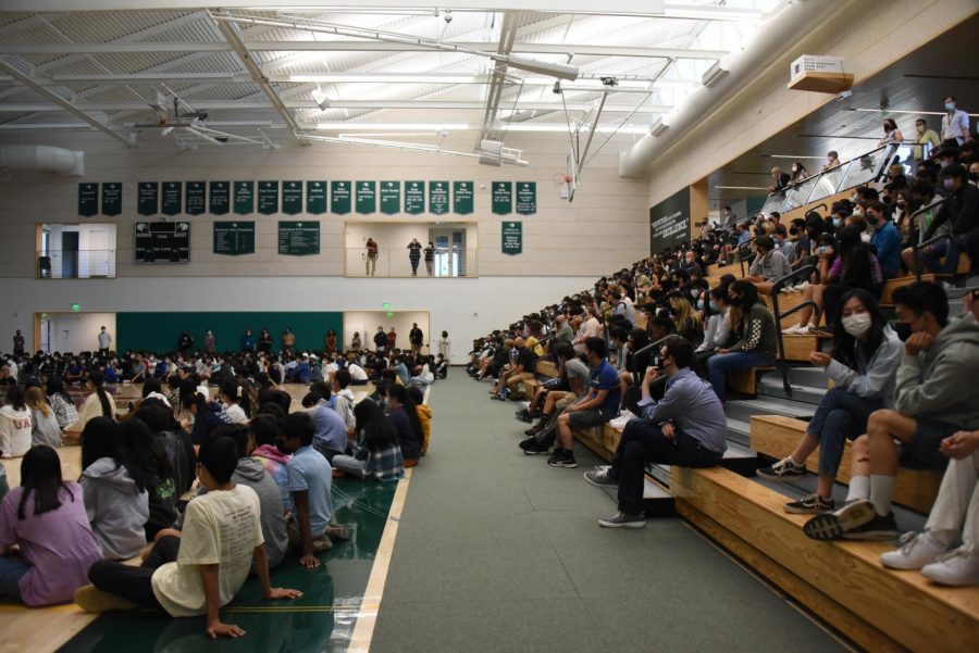 Seniors, juniors and faculty sit on the gym bleachers while freshmen and sophomores sit on the Zhang Gymnasium floor during school meeting. The seating chart, which was displayed at the beginning of the meeting, arranges junior and senior advisories by row.