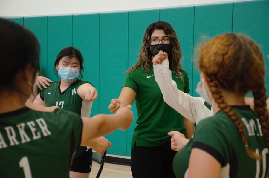 Catherine Wong (10) and assistant coach Serena Chandler join the team in a cheer right before the game begins.