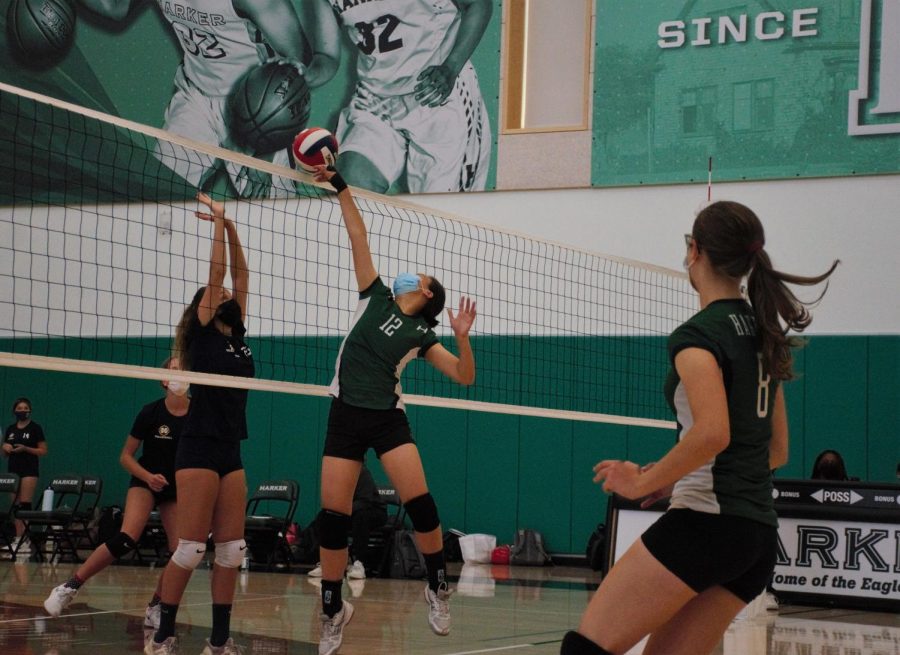 Yifan Li (9) extends her arm to tip the ball over the net while Emily McCartney (10) watches on.