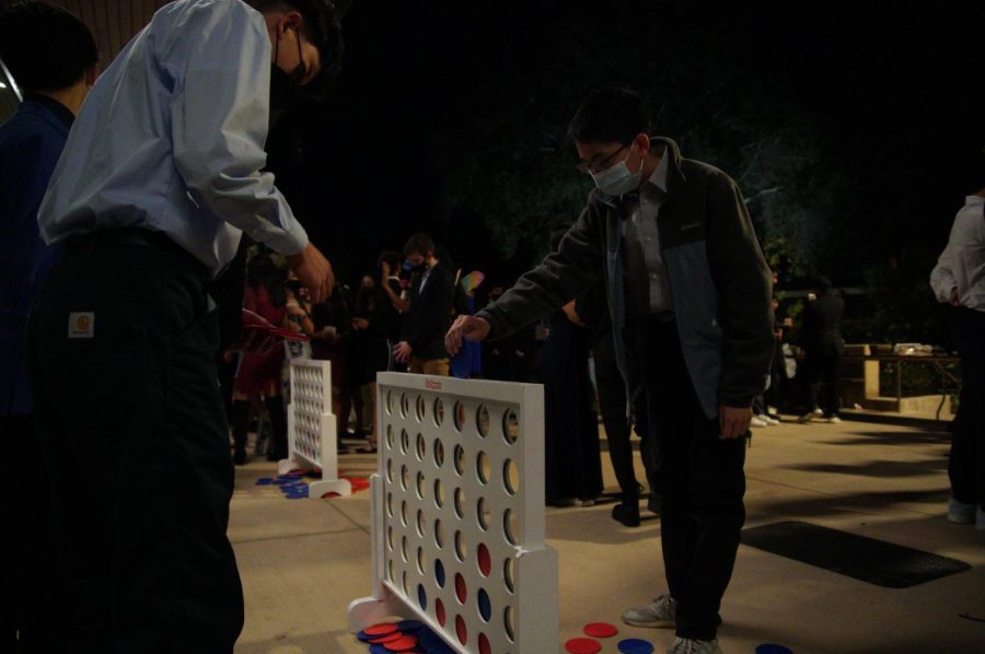 Sophomores Andrew Tang (10) and Bryan Xiao (10) play a round of Connect 4 during the Homecoming Dance.