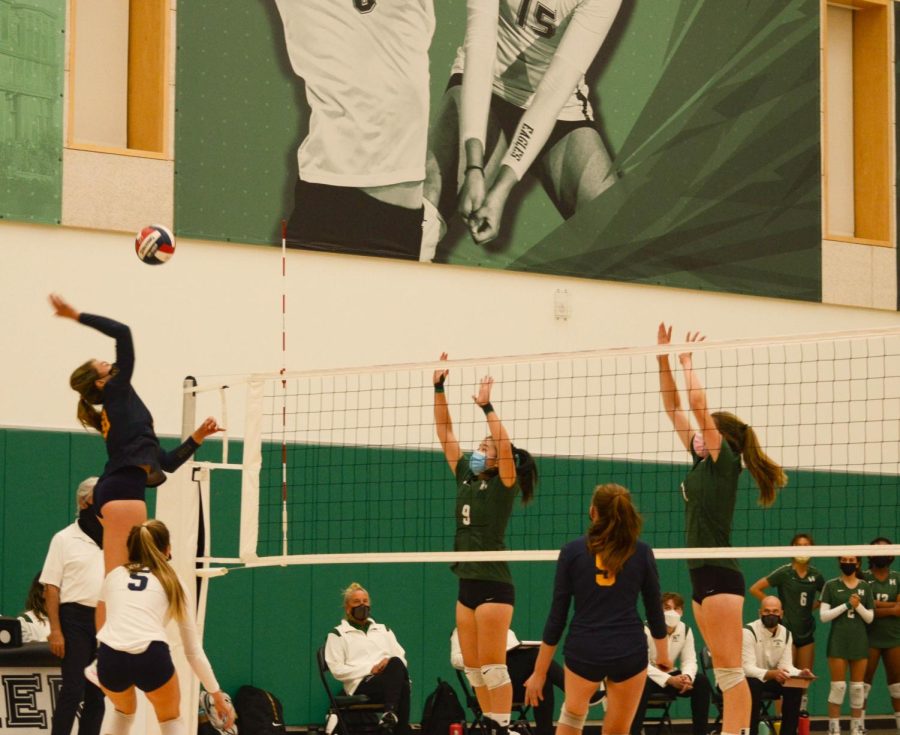 Jessica Tang (11) and Liza Shchegrov (12) reach up before a Menlo player spikes the ball.