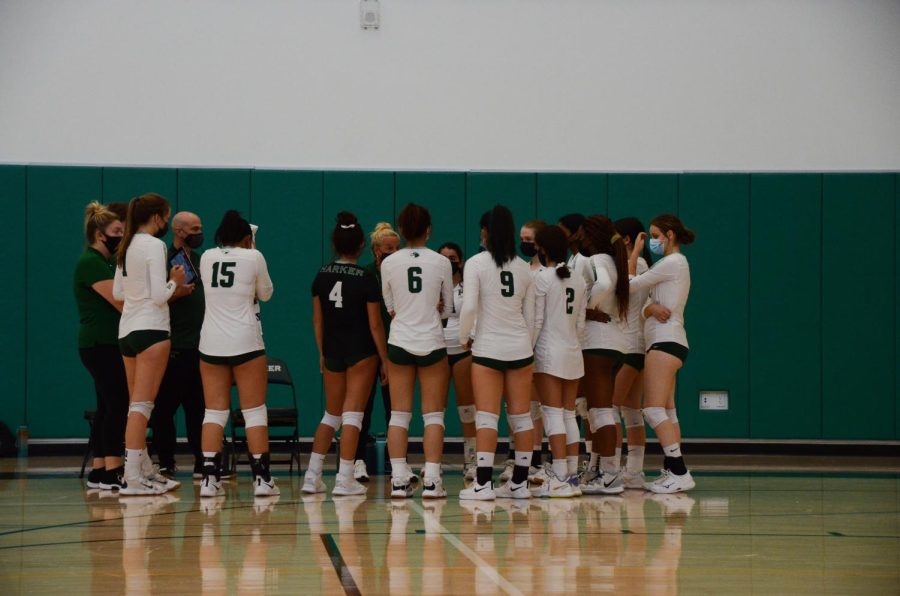 The varsity girls volleyball team huddles up for a timeout in the first set.
