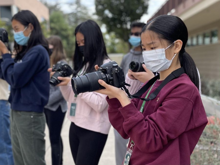 Reporter Ella Yee (10) reviews photos taken of a table tennis match between Director of Journalism Ellen Austin and Winged Post Managing Editor Mark Hu (12). All periods of news-based journalism students engaged in action photography practice today. 