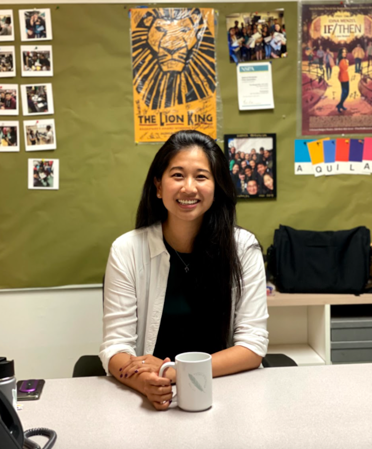 Upper school Intro to Journalism teacher Whitney Huang sits at her desk in the back room of the journalism classroom, holding her Harker Journalism mug. Huang, a 2008 alumna and Harker lifer, returned to Harker due to her deep connection to the schools culture and environment. 