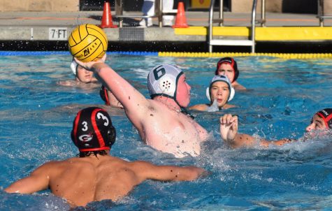 Lachlan Rossi (10) throws the ball into the goal as two Gunn defenders close in on him. After finishing second in league this season with a record of 11-2, the varsity boys water polo team won CCS and finished second place in NorCals.