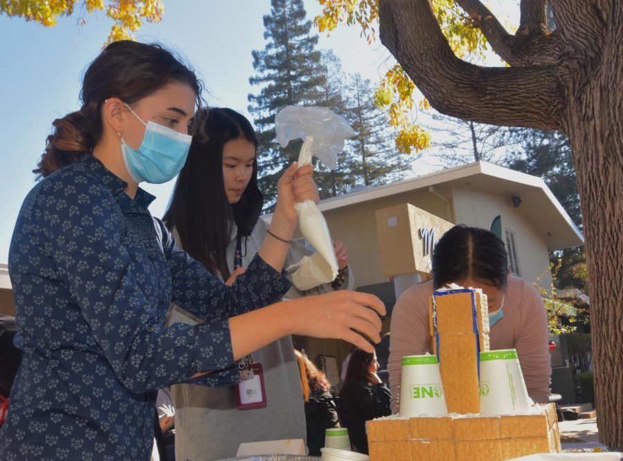 Paulina Gicqueau (11) pipes frosting on the Class of 2023 gingerbread tower, alongside Sawyer Lai (11) and Ashley Ma (11). The Class of 2023 won the gingerbread house decorating competition, held during lunch on Nov. 29.
