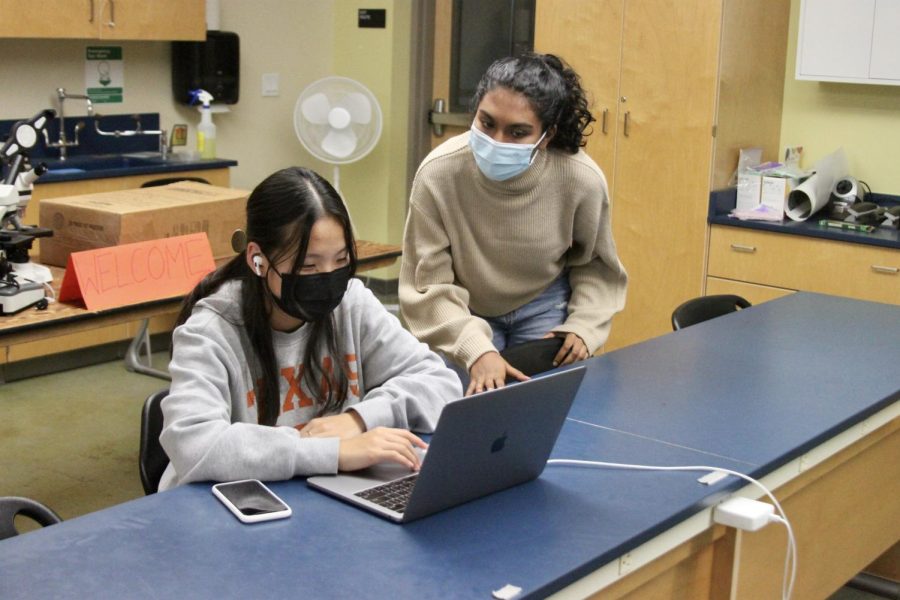 WiSTEM co-president Kavita Murthy (12) looks on with Ashley Hong (10) during the TechGirlz workshop. Officers went around each of the three science rooms to check in with the club members while they were hosting.
