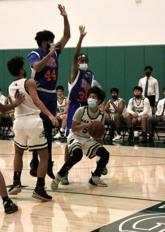 Holding the basketball, Kevin Zhang (10) crouches to see if any of his teammates are open. The boys beat University Prep Academy 67-24 on Tuesday, Nov. 30.