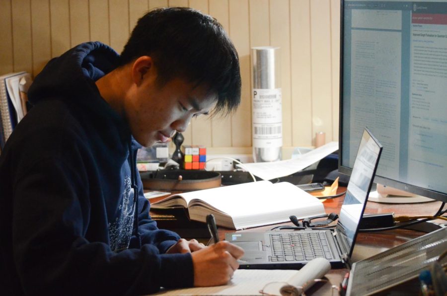 Alex Hu (12) writes equations and data for his math research project. Throughout his research, he looked at quantum code written for error correction.
