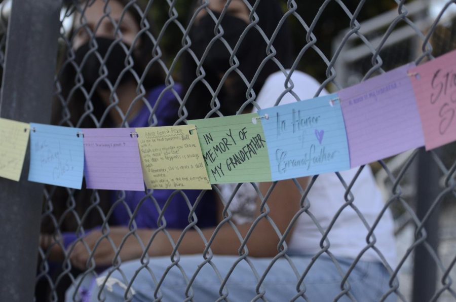 Multicolored notecards with memories of the players loved ones decorate the fence of the bleachers. Members of the soccer teams prepared for the Kicks Against Cancer games by creating posters and writing the cards.