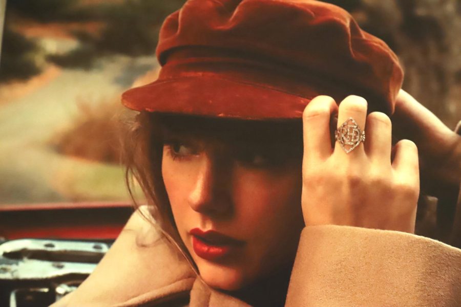 Taylor Swift, in a red hat and lipstick, poses on the album cover photo of Red (Taylors Version). Swifts re-recording features 9 From the Vault tracks, which were previously never released. 